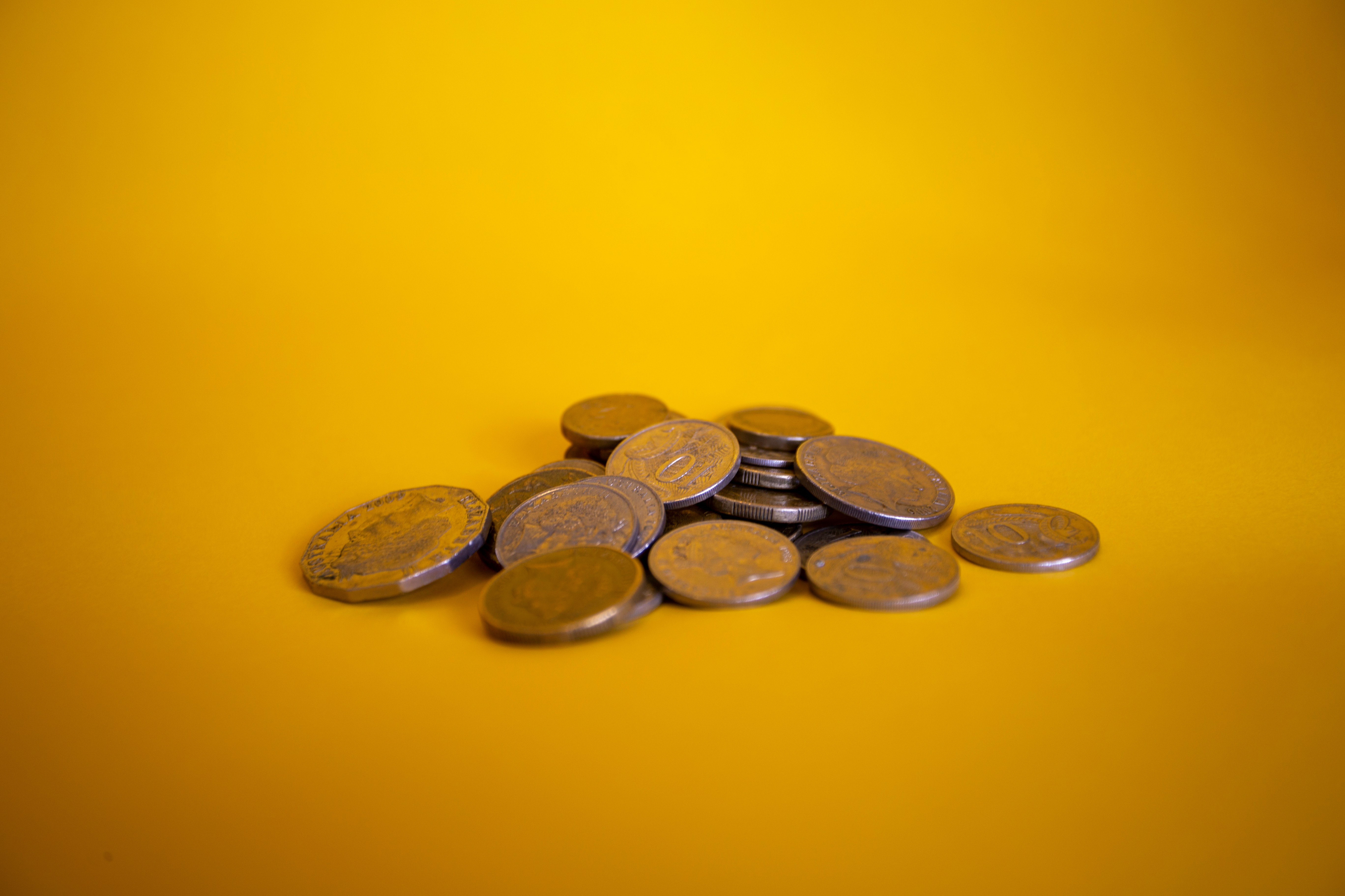 Pile of coins on a yellow background